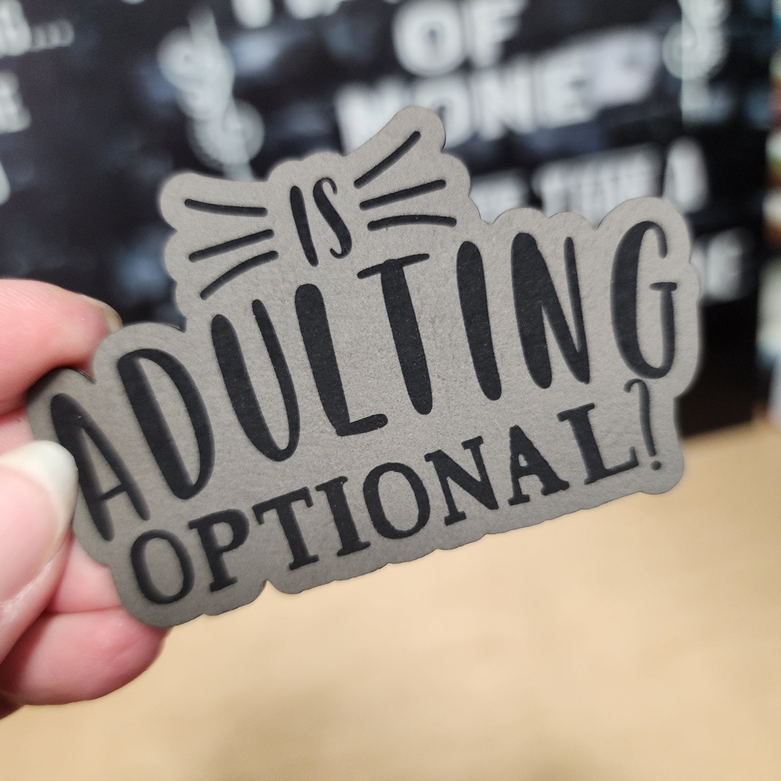 Funny leatherette hat patch reading 'Is Adulting Optional?' perfect for quirky accessories and gifts.