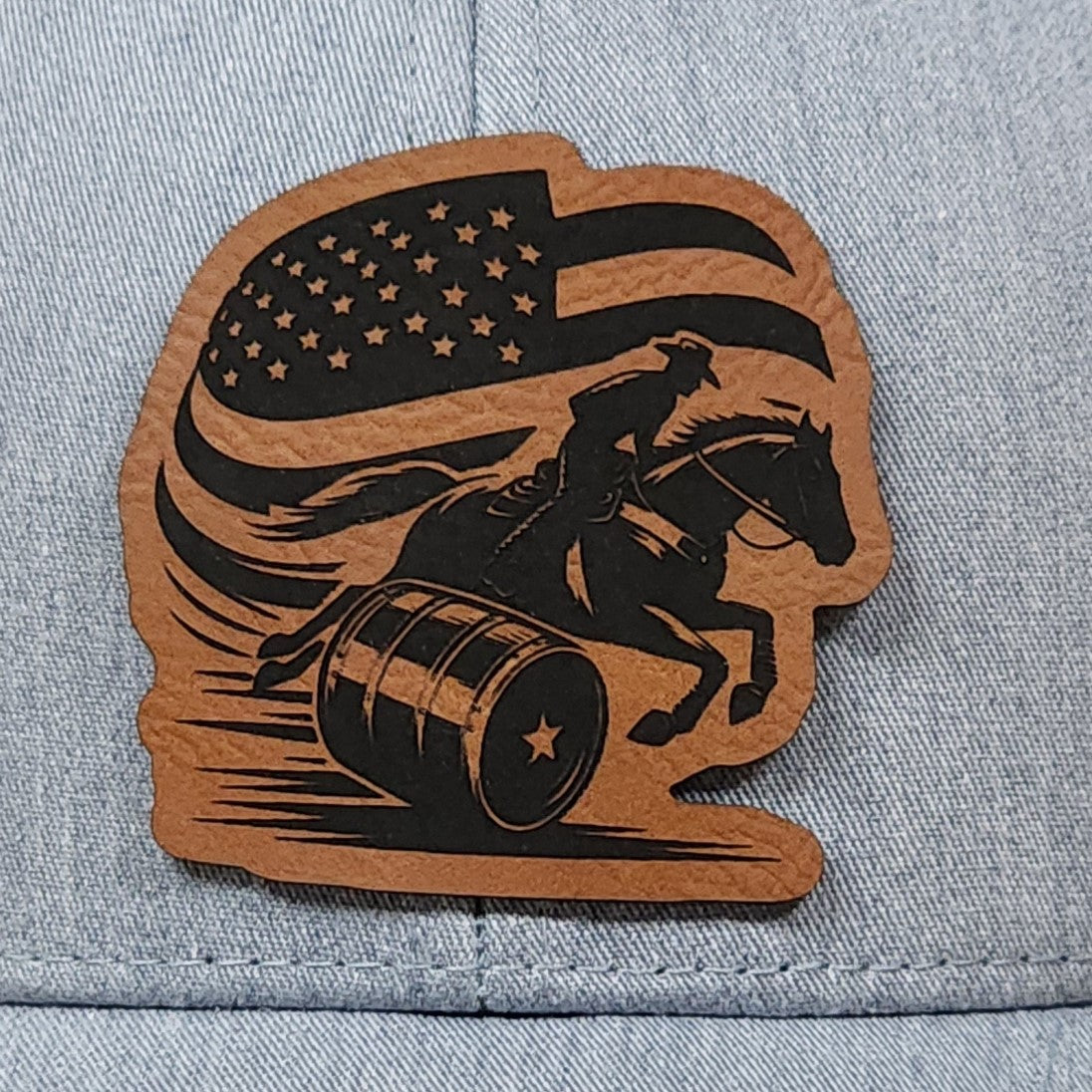 Barrel racing leatherette hat patch featuring a cowboy riding a horse with an American flag design.