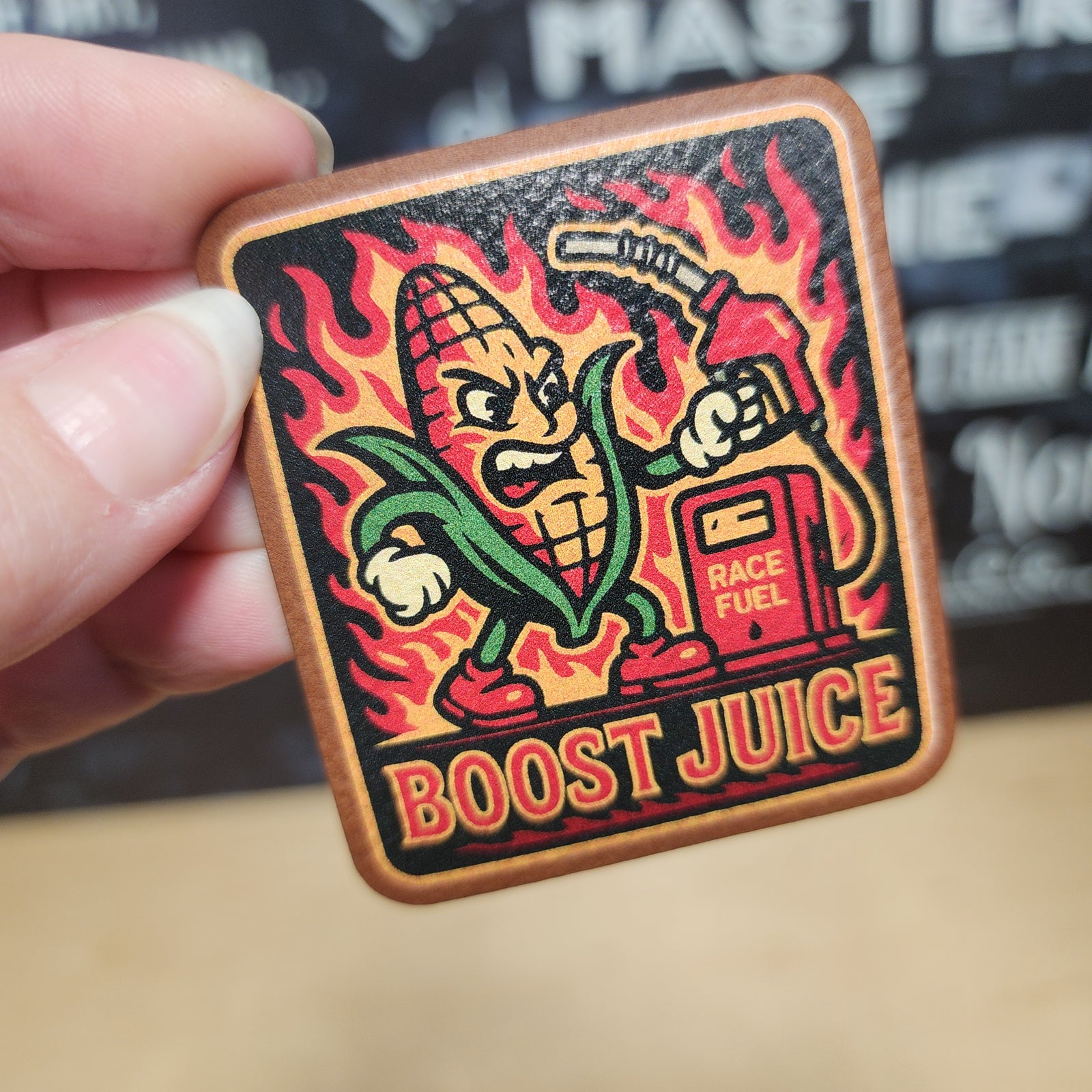Boost Juice leatherette hat patch featuring a fiery corn character with a fuel pump, perfect for racers.